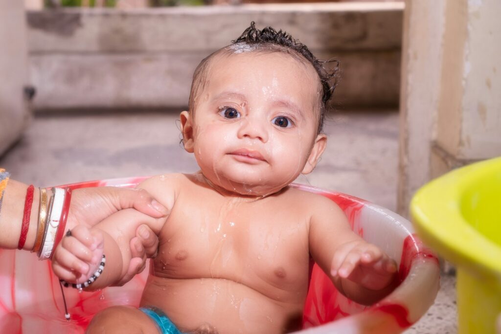 Baby baden in einer kleinen Wanne: Säugling beim sanften Waschen