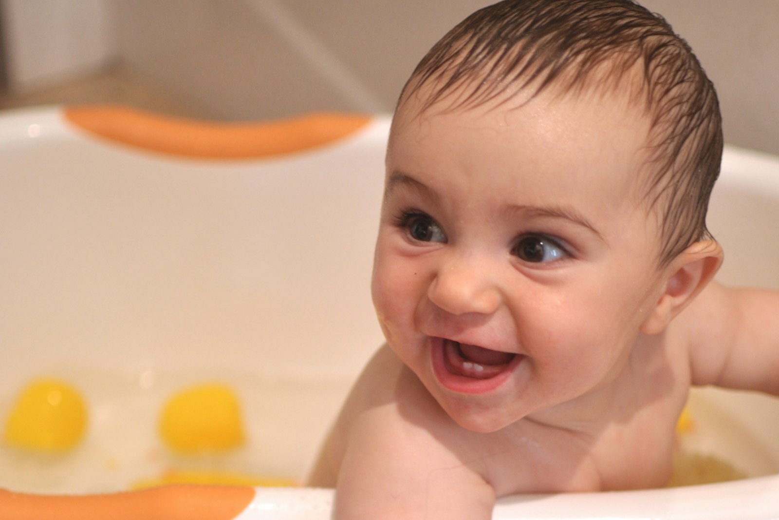 Baby baden: Mutter badet ihr Baby in der Babywanne