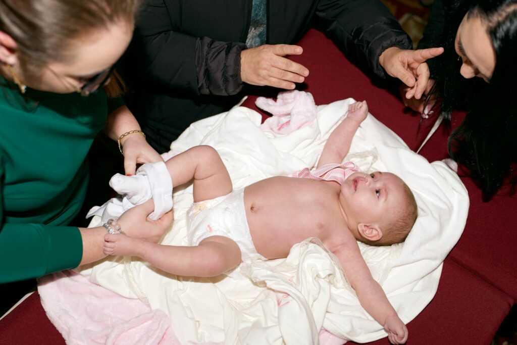 Eltern beim Baby wickeln auf einer weißen Decke