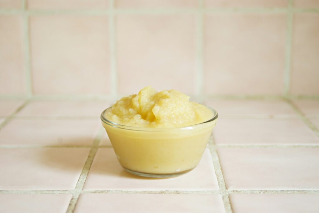 Gelber Brei in einer Glasschale – Babybrei selber machen aus Kürbis und Möhre