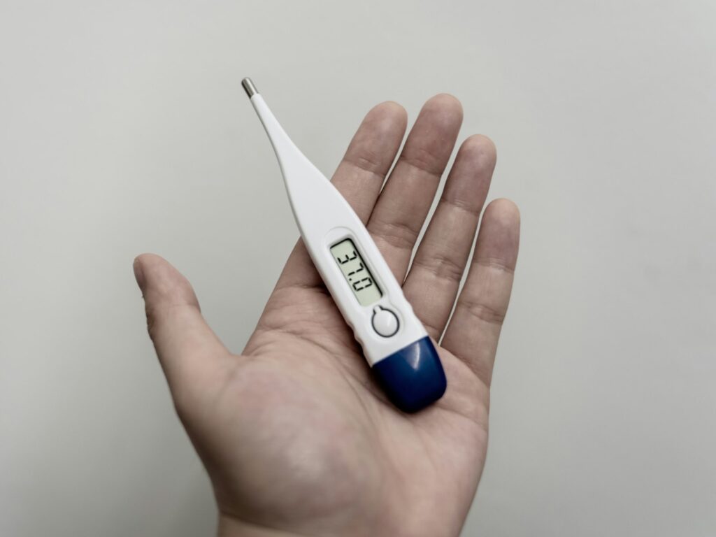 Fieber beim Baby messen: digitales Fieberthermometer zeigt eine normale Temperatur an