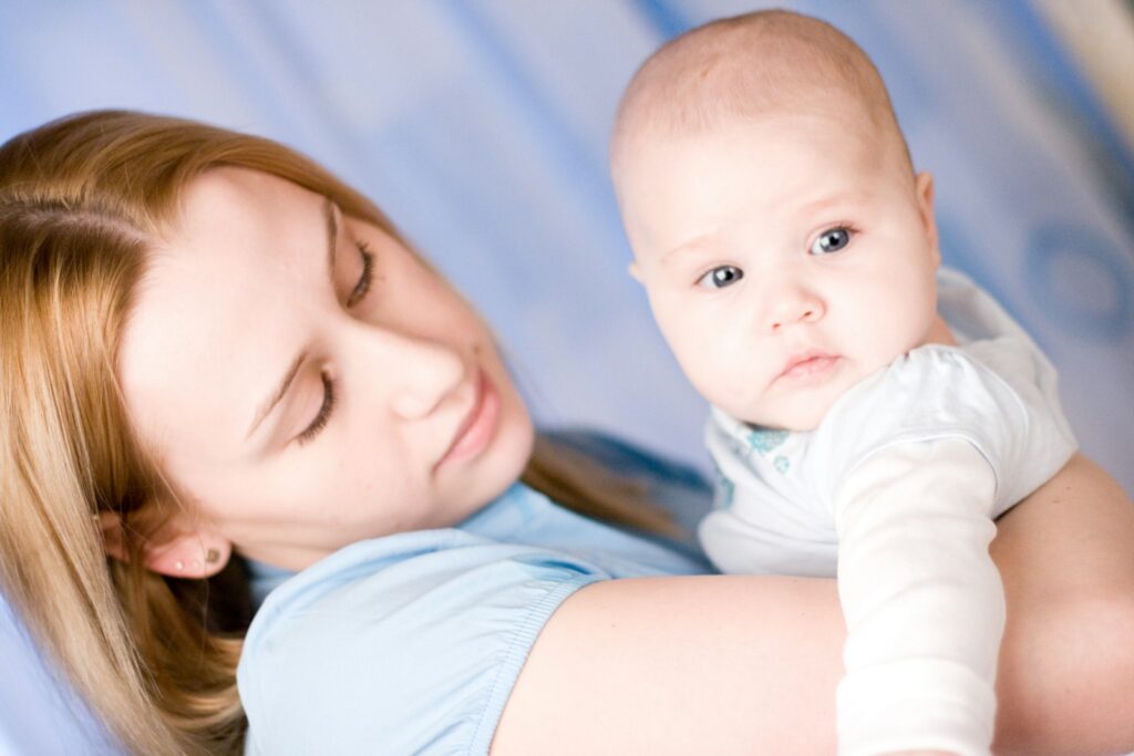 Fieber beim Baby: Mutter hält ihr Kind tröstend im Arm