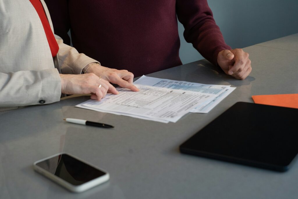 Zwei Personen prüfen gemeinsam Unterlagen für Mutterschutz und Mutterschaftsgeld