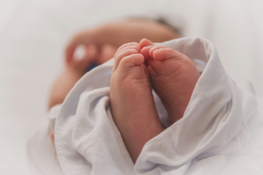 Baby unter einer weißen Decke nach erfolgreicher Nabelpflege
