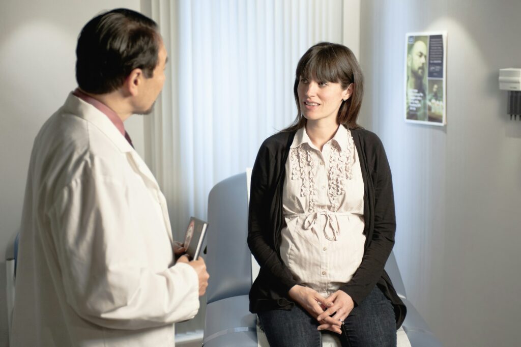 Ärztin im Gespräch mit einer Schwangeren während der Schwangerschaftsvorsorge