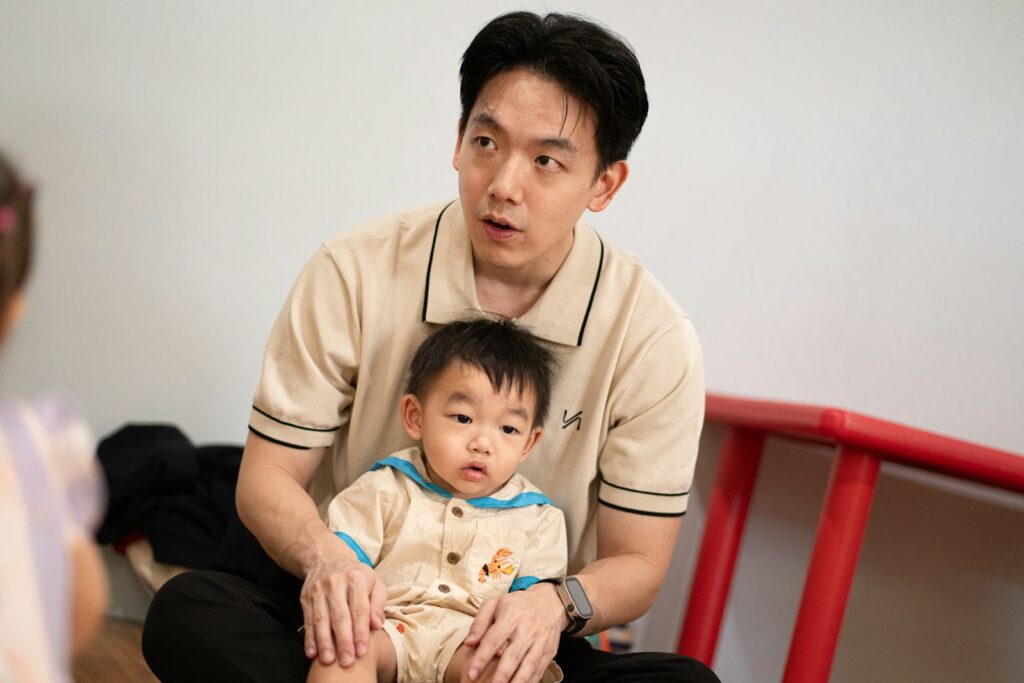 Vater hält sein Baby auf dem Schoß und plant den Wiedereinstieg nach der Elternzeit
