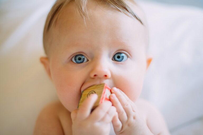 Zahnen beim Baby: Baby kaut auf einem Holzwürfel